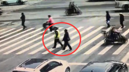 盲人男子红灯时欲穿马路 辅警拦下后用盲杖牵其过马路