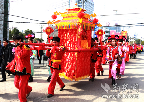 四个身穿红色古代服装的壮汉抬着大花轿.通讯员 宋俊初摄